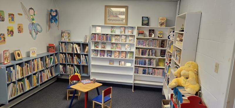 The children's corner of the library, with picture books, a kid-sized table and chairs